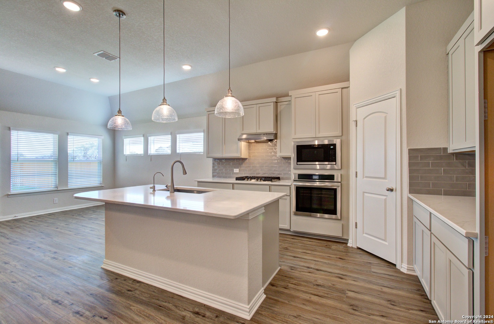 a kitchen with kitchen island a sink stainless steel appliances and cabinets