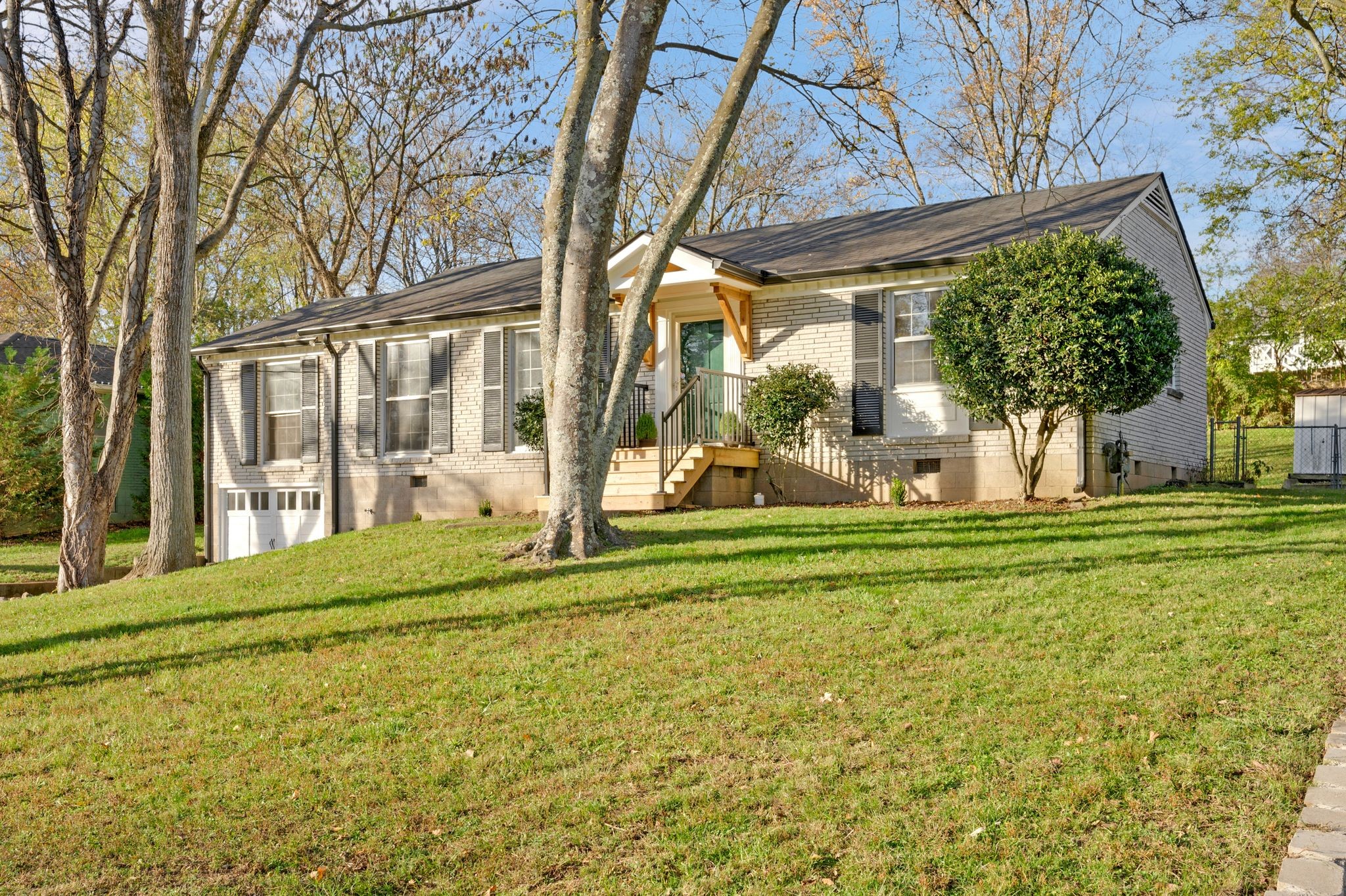 a view of a house with a big yard and large trees