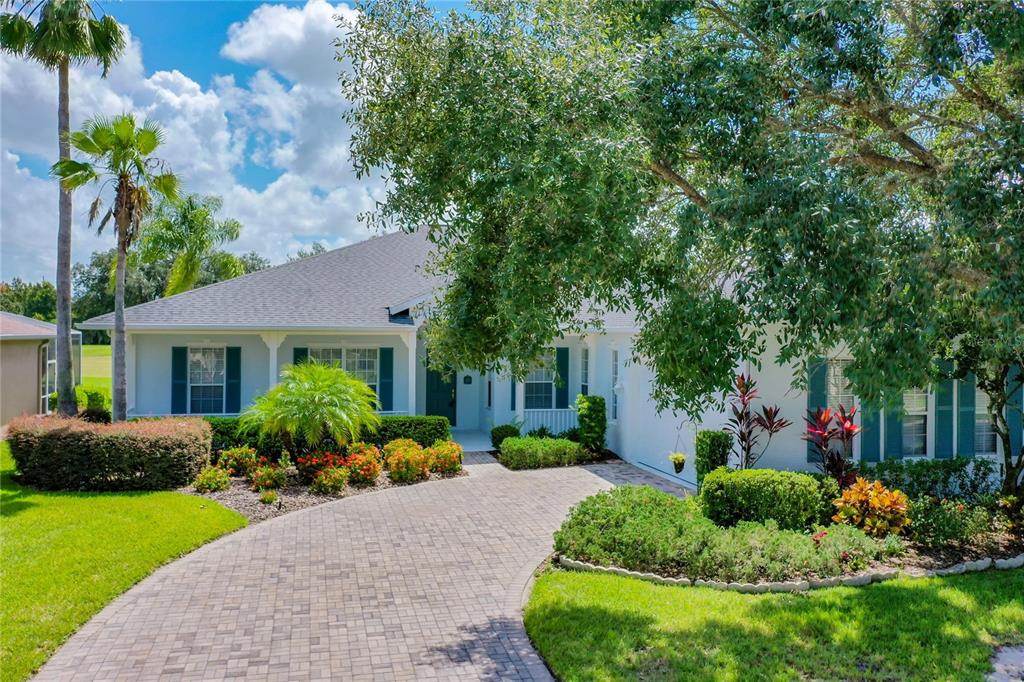 a front view of a house with a yard and potted plants