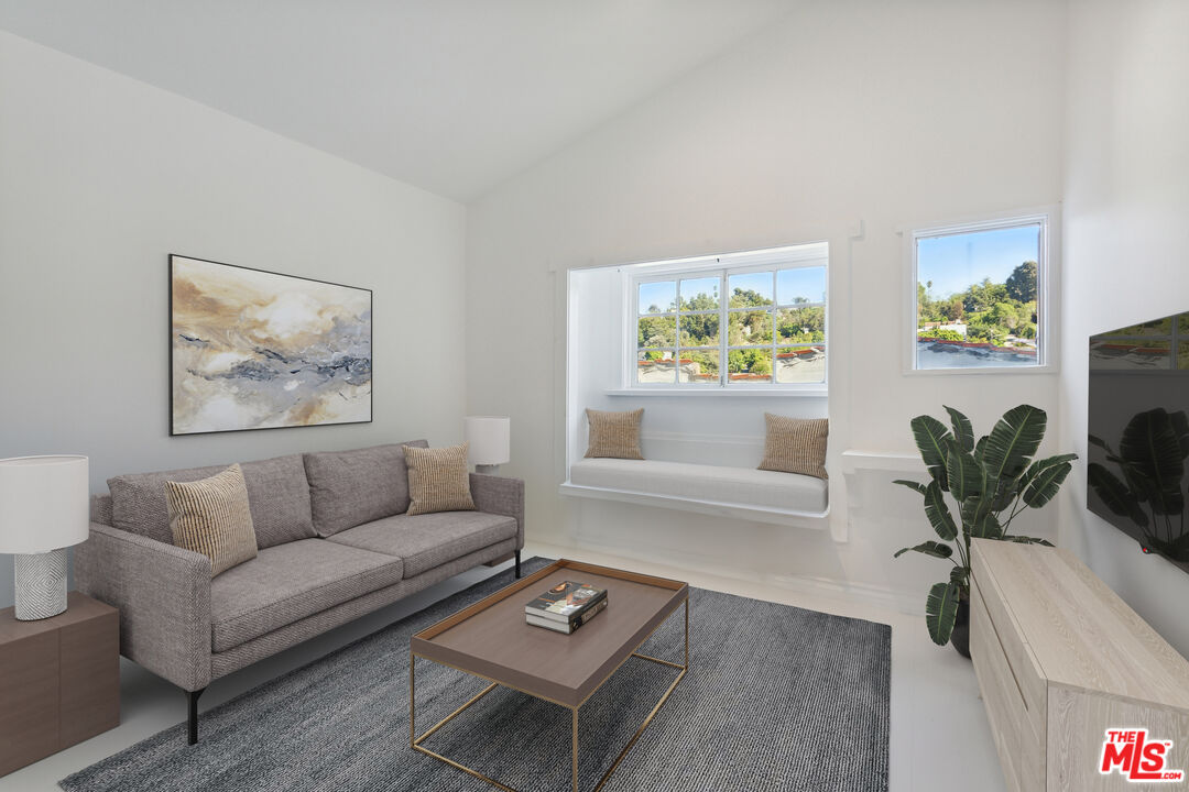 a living room with furniture a potted plant and a window