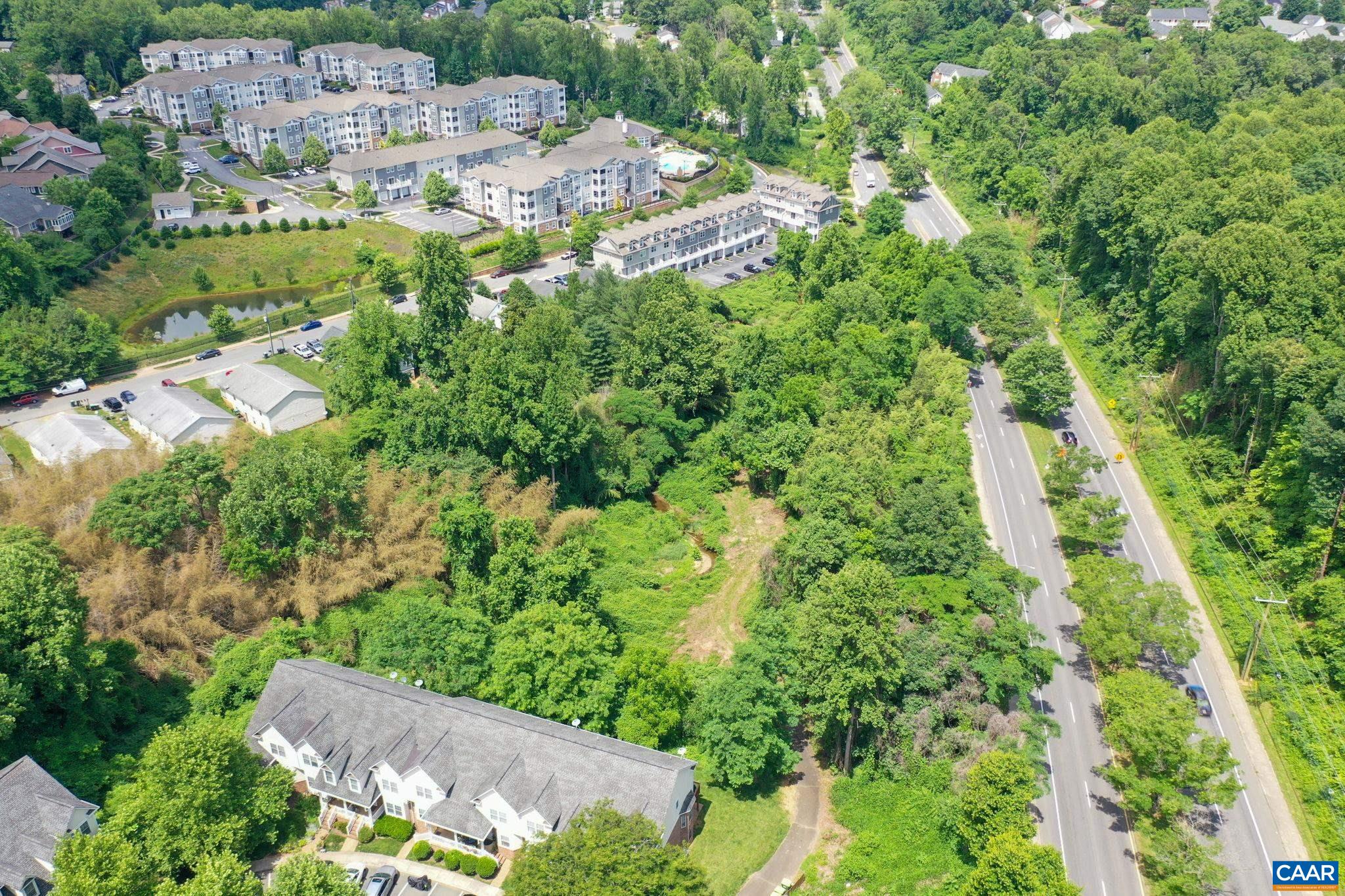 an aerial view of residential house with outdoor space and trees all around