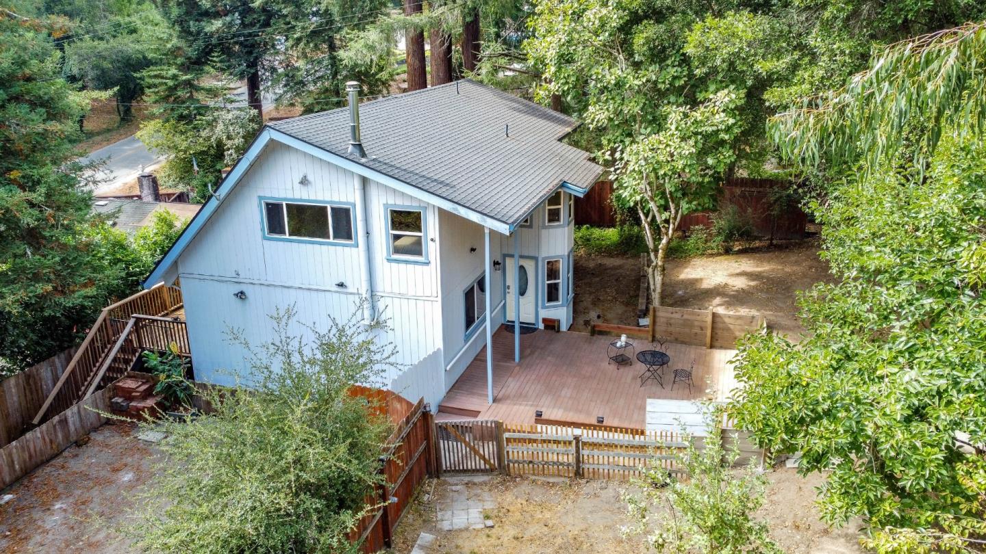 a aerial view of a house with table and chairs under an umbrella