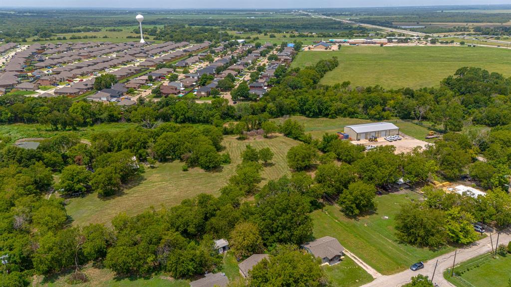 an aerial view of residential houses with outdoor space and trees