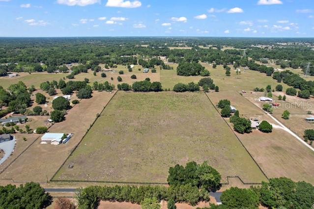 an aerial view of a house with a yard and lake view