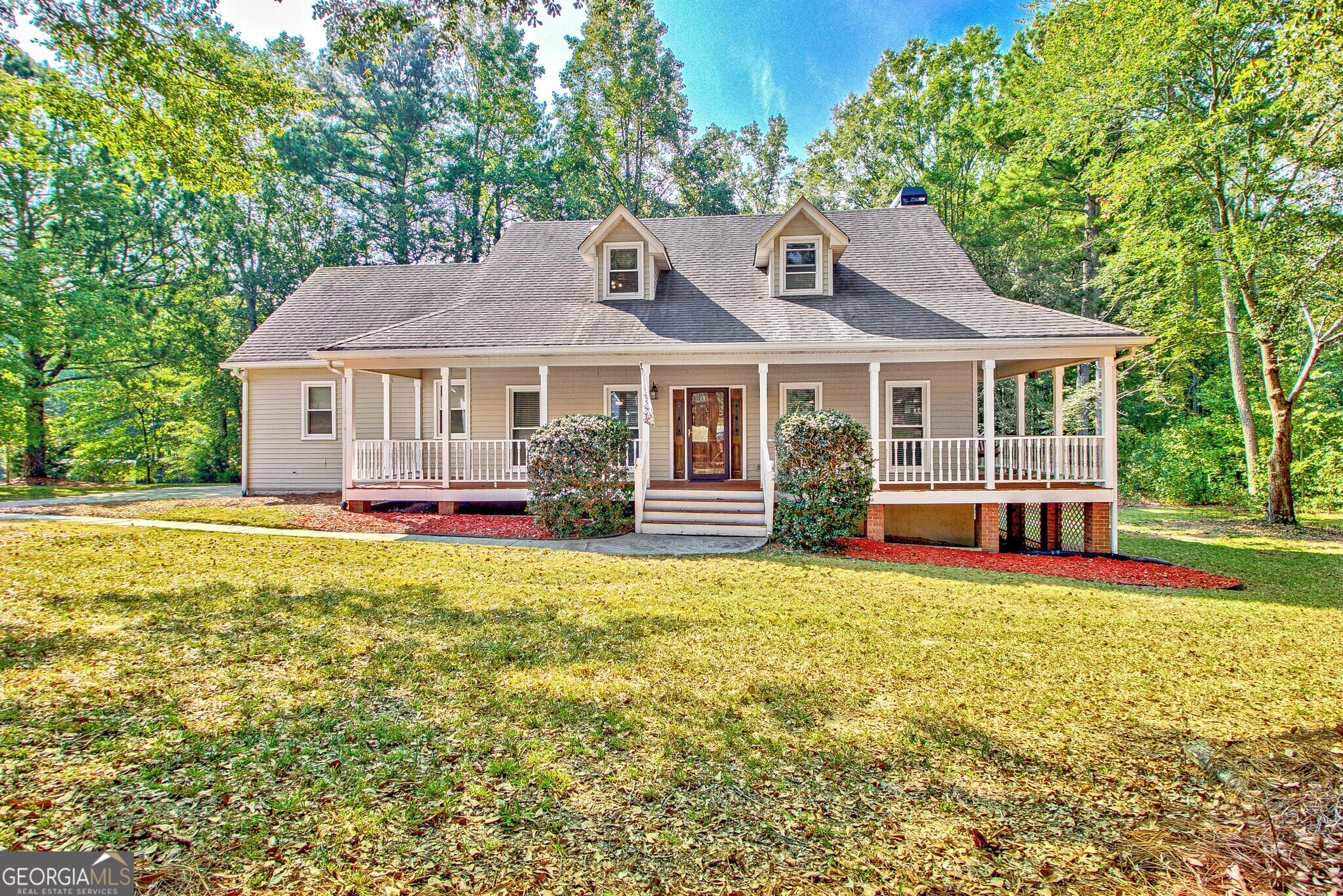 a front view of a house with a yard and trees