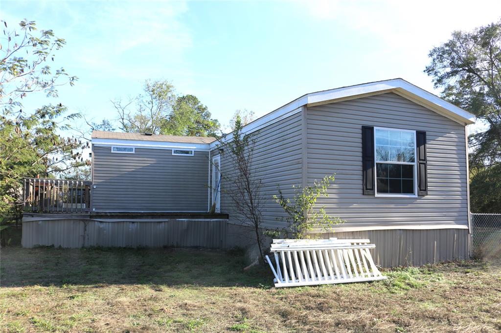 a view of a house with a yard and wooden fence