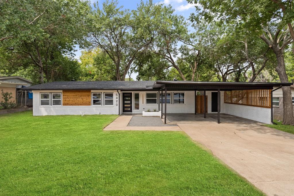 Front of property featuring a carport and a lawn