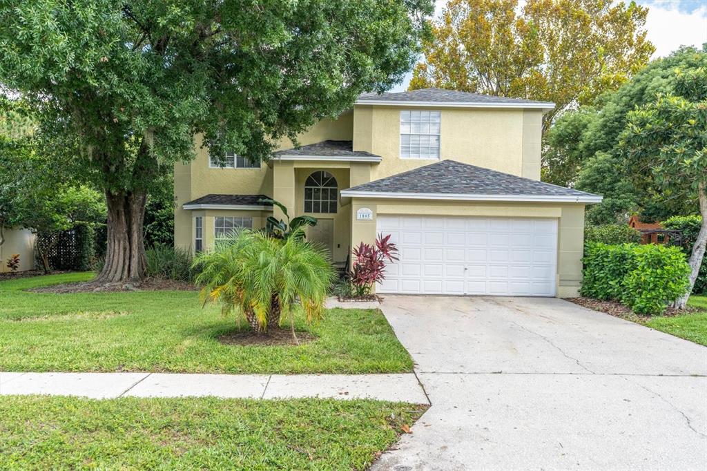 a front view of a house with a yard and trees