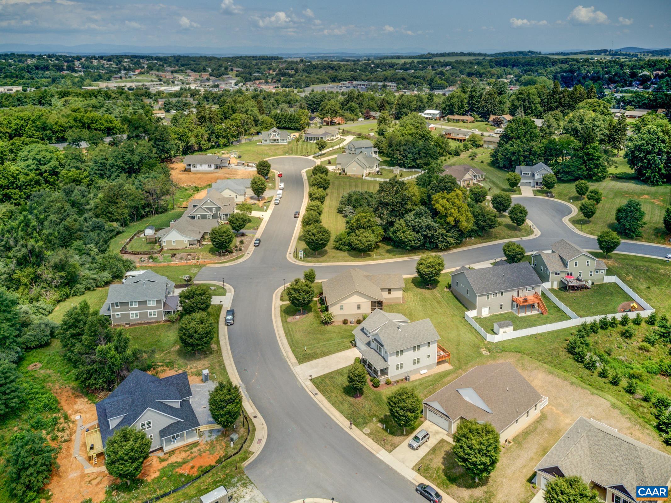 an aerial view of residential houses with outdoor space and parking