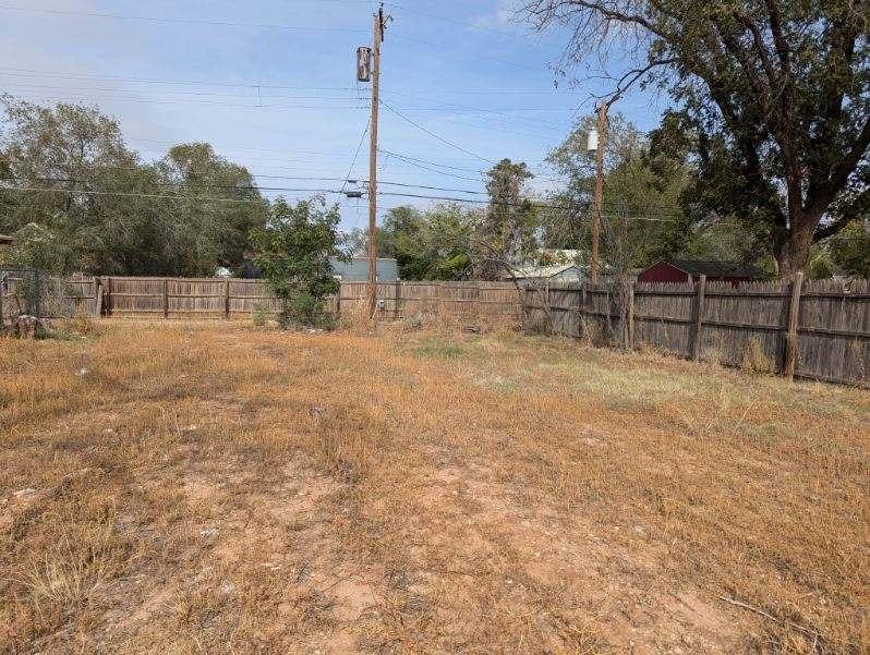 a view of backyard with a fence