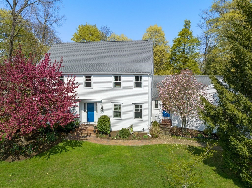 a view of a white house with a yard and potted plants