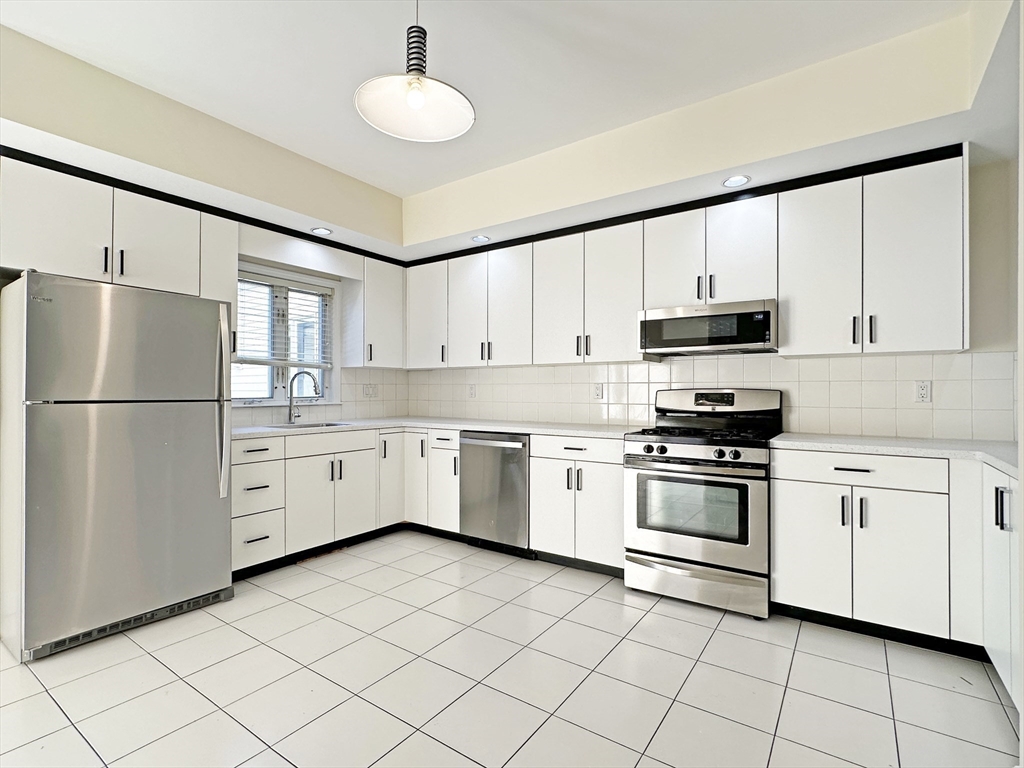 a kitchen with white cabinets and white appliances