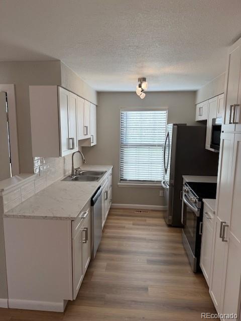 a kitchen with granite countertop a sink stove and refrigerator