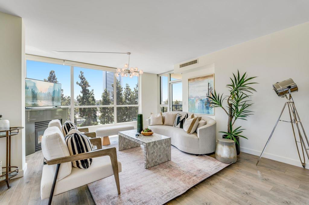 a living room with furniture potted plant and a large window