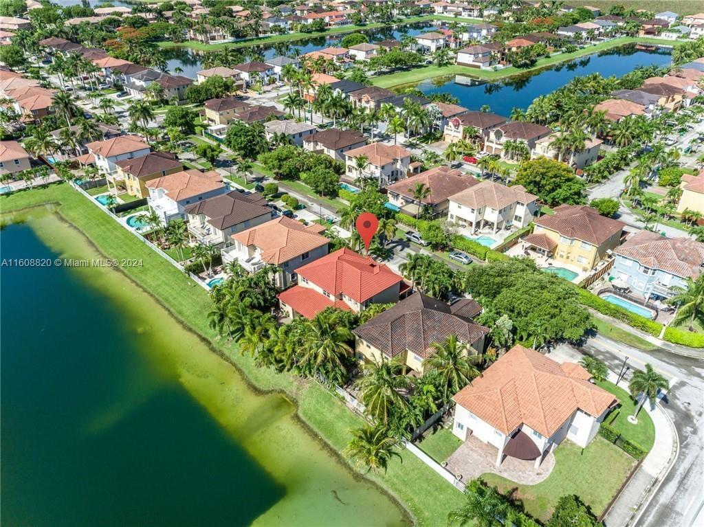 an aerial view of residential houses with outdoor space and trees