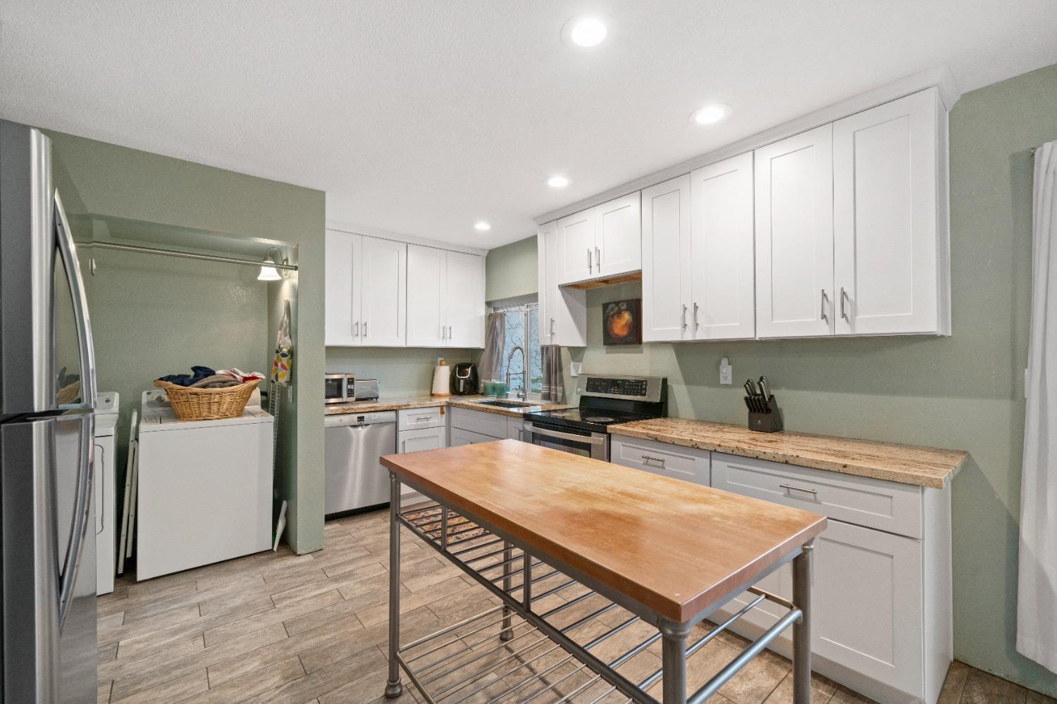 a kitchen with a refrigerator a stove top oven a sink and cabinets