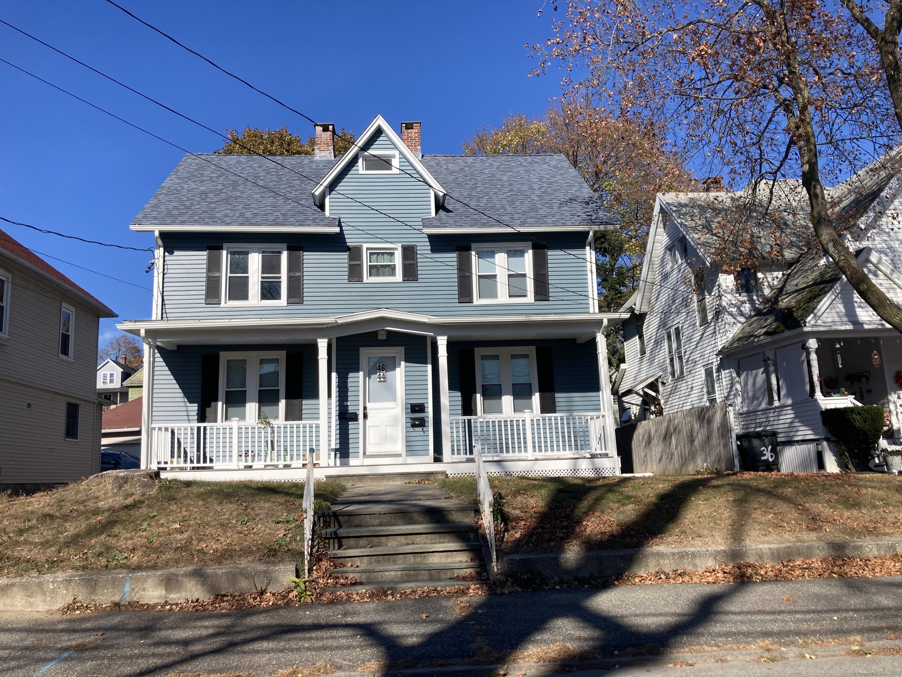 a front view of a house with a tree