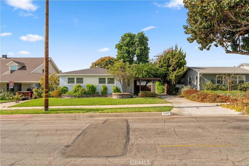 a view of a house with a big yard and palm trees