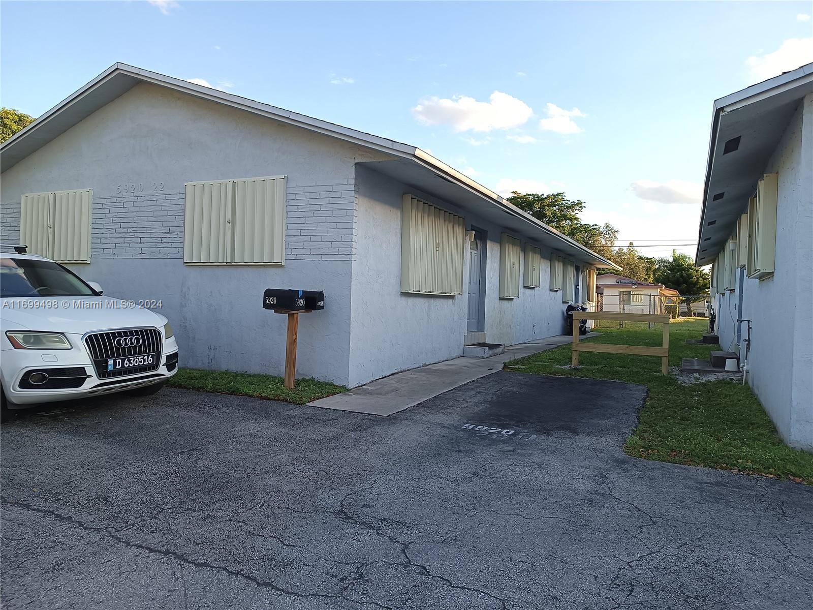 a view of a house with backyard space and a car parked in it