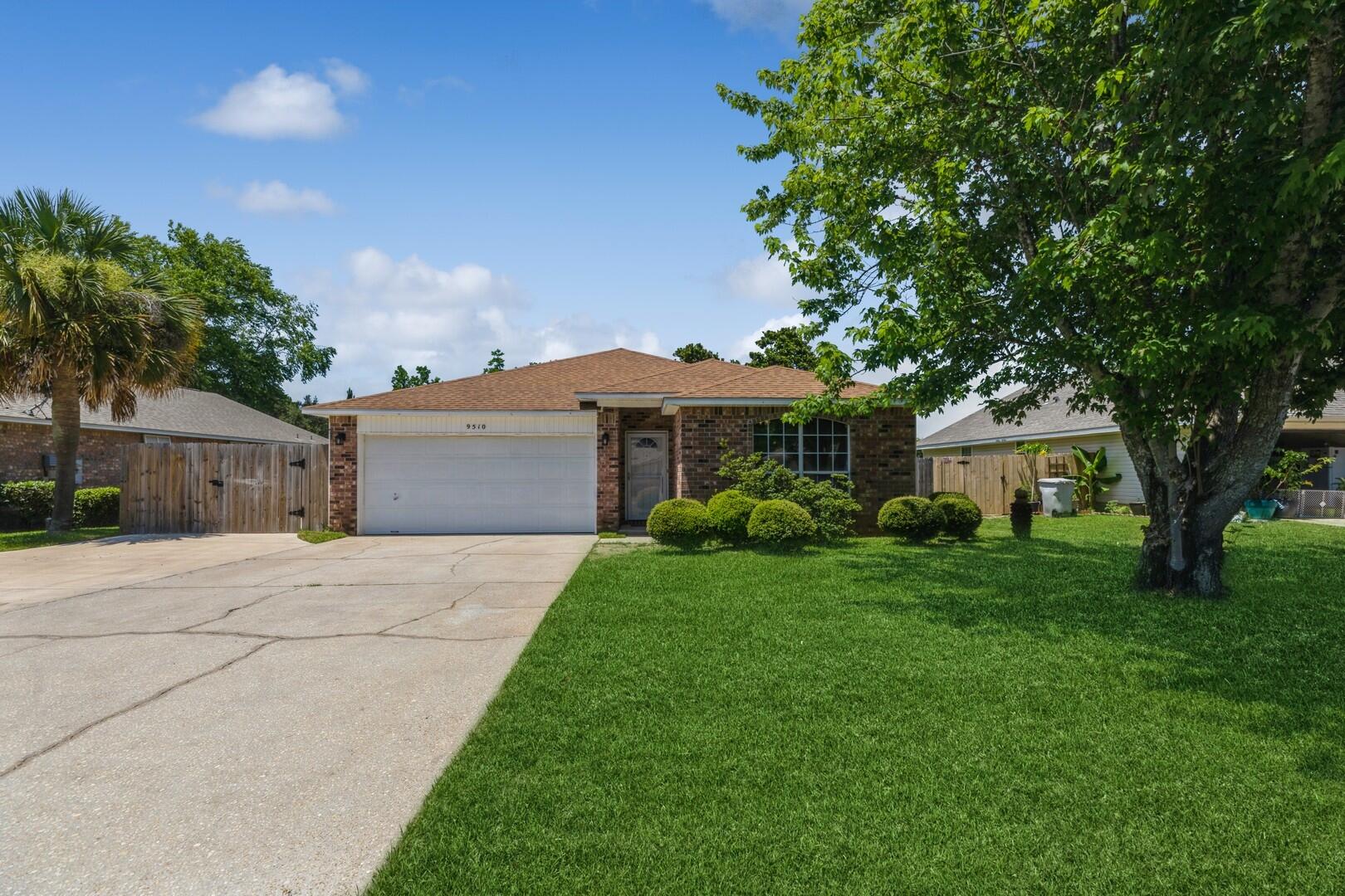 a front view of a house with a garden and trees