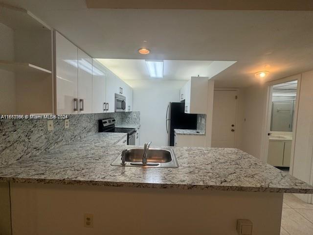 a kitchen with kitchen island sink and refrigerator