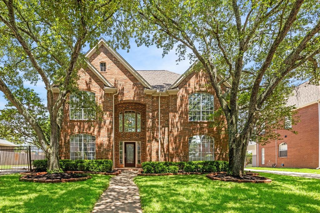 front view of a brick house with a yard