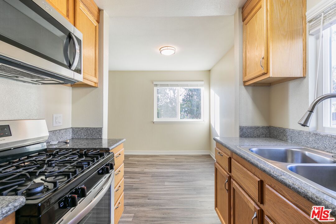 a kitchen with stainless steel appliances granite countertop a sink and a stove