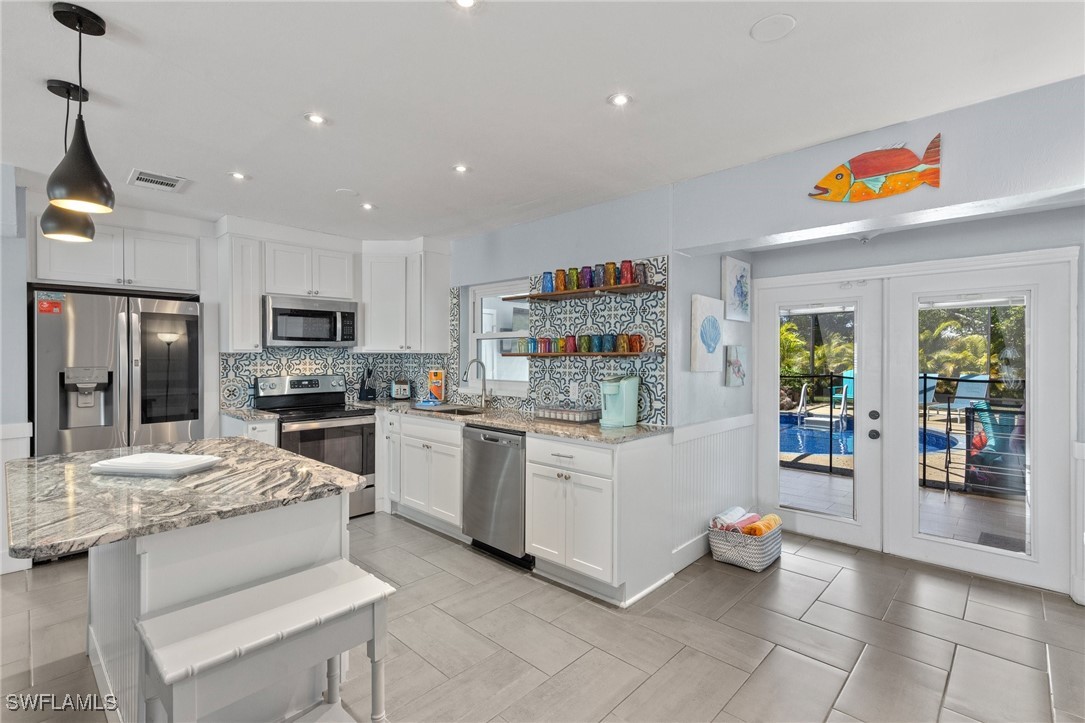 a kitchen with stainless steel appliances kitchen island granite countertop a refrigerator and microwave