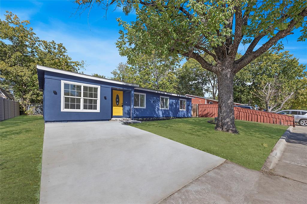 a view of a house with a yard and large tree