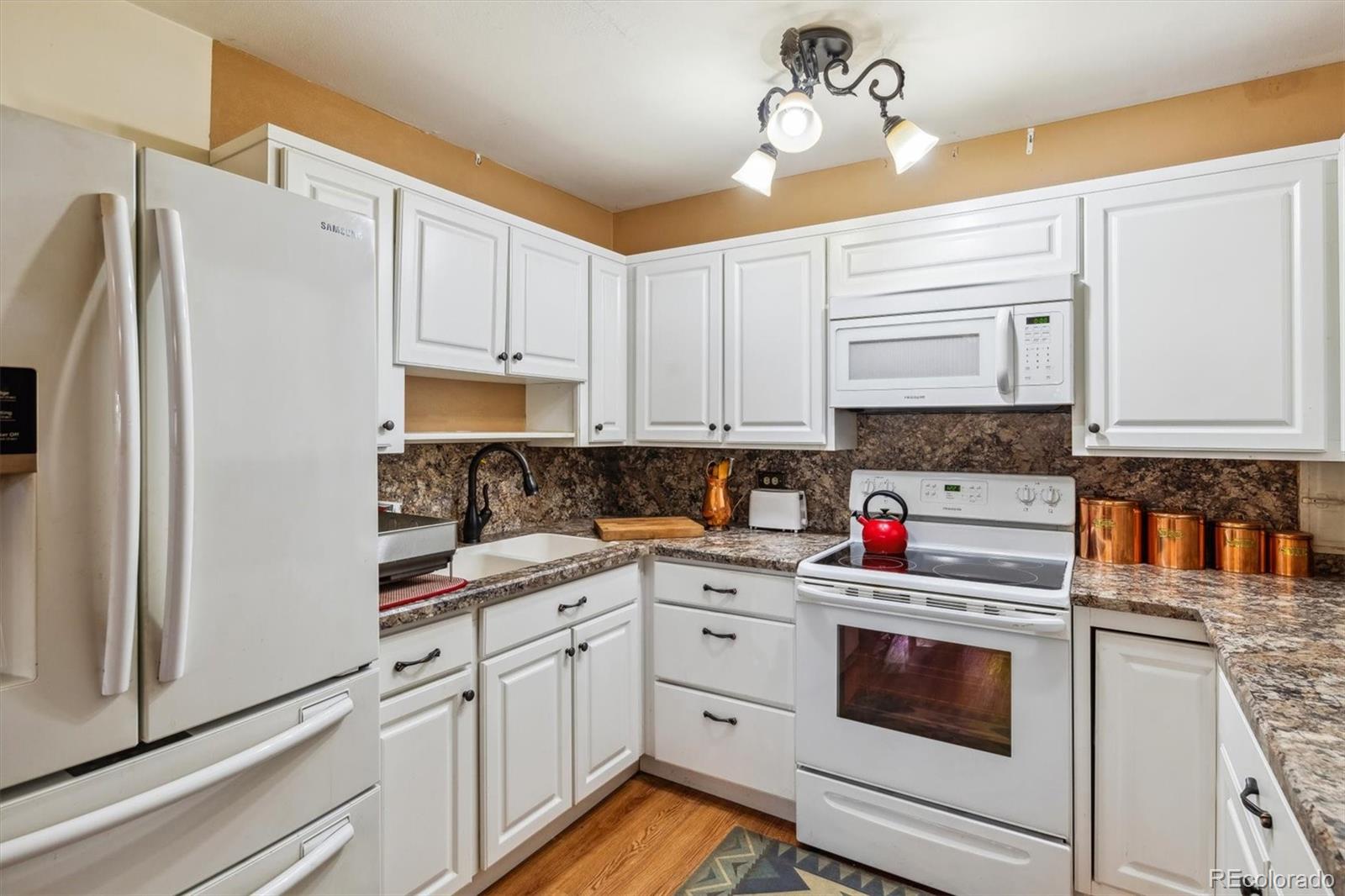 a kitchen with stainless steel appliances white cabinets and white appliances