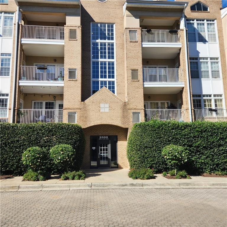 a front view of a building with a garden and entryway