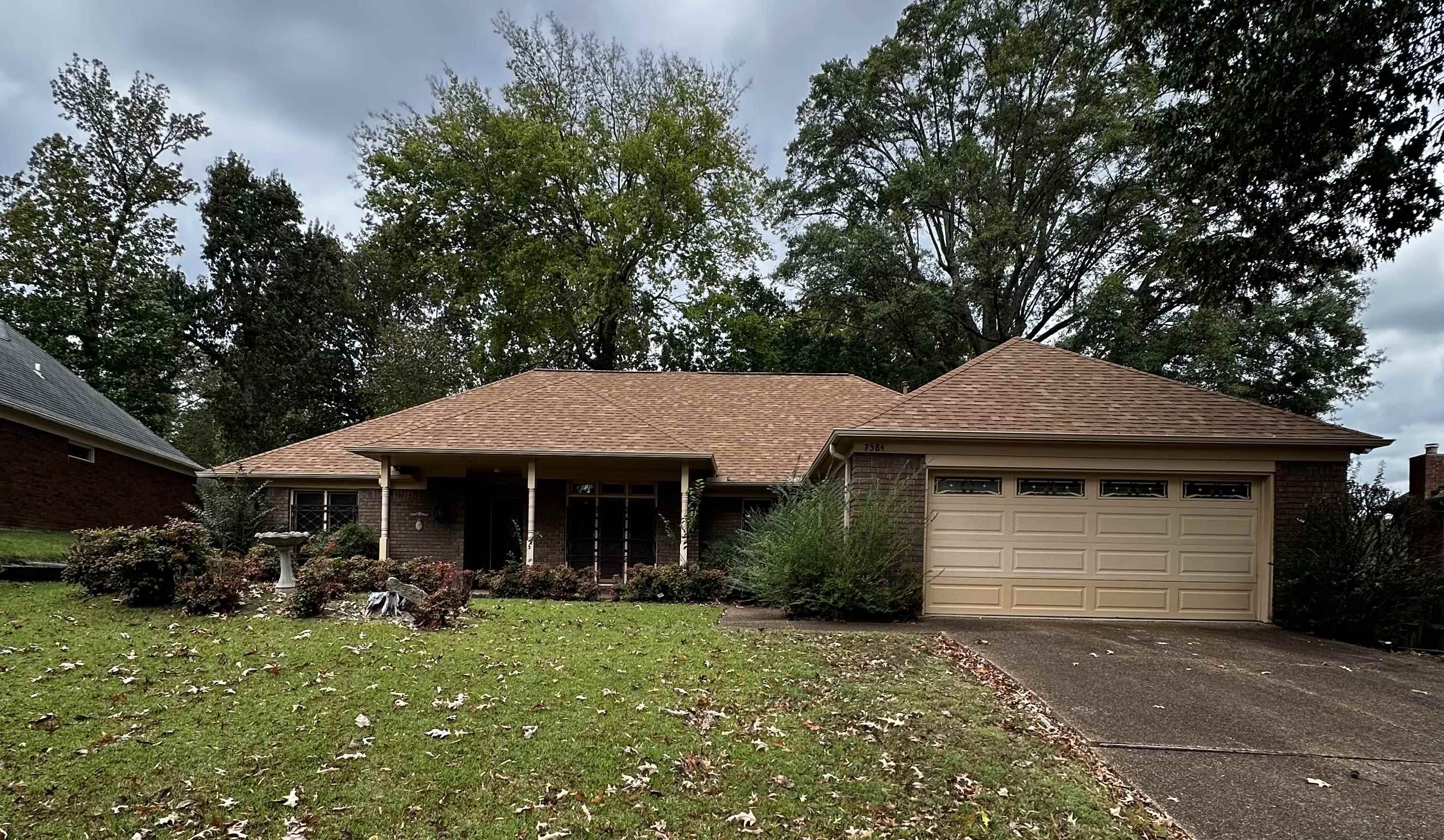 Single story home with a garage and a front lawn