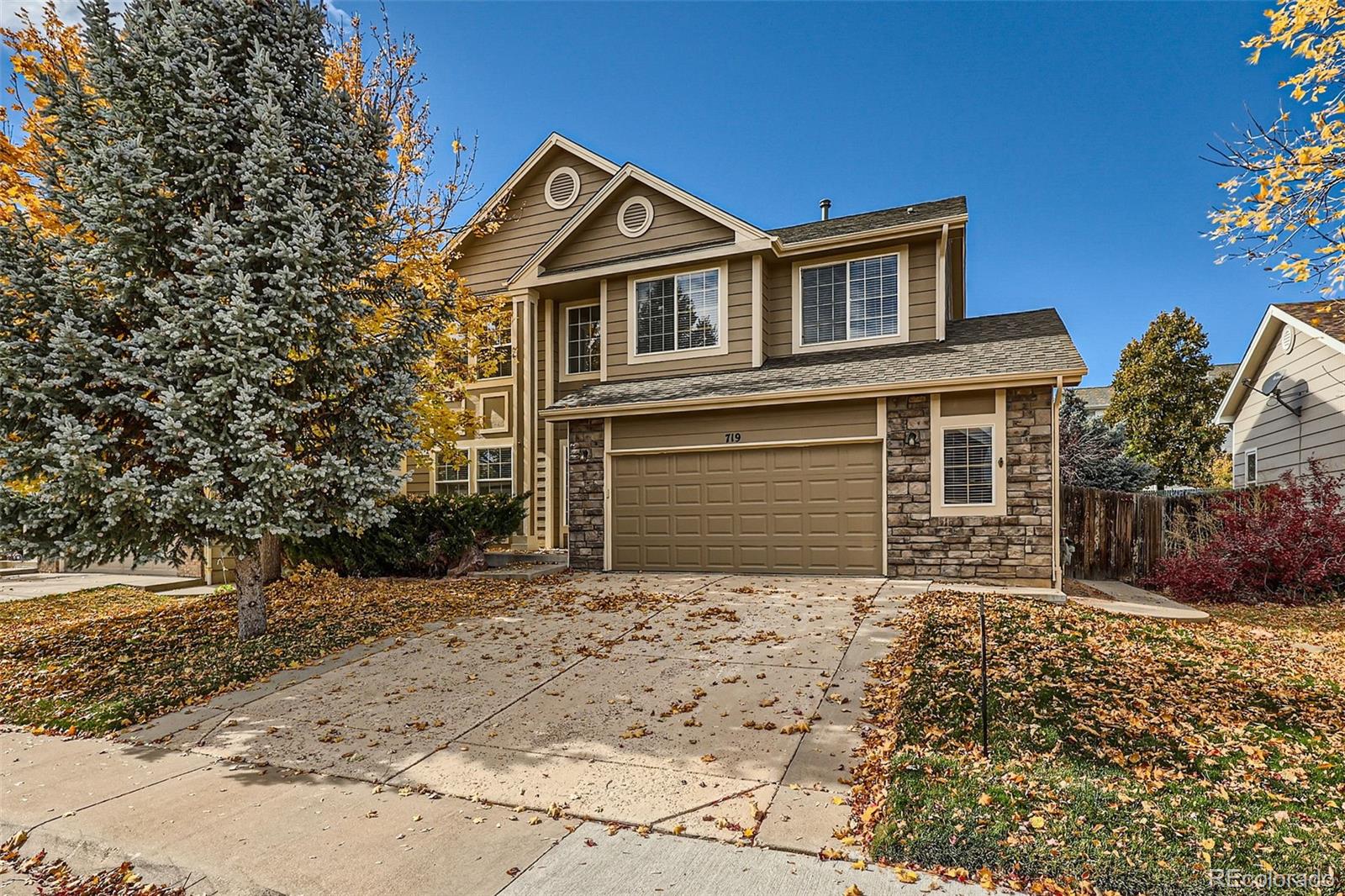 a front view of a house with a yard covered with snow