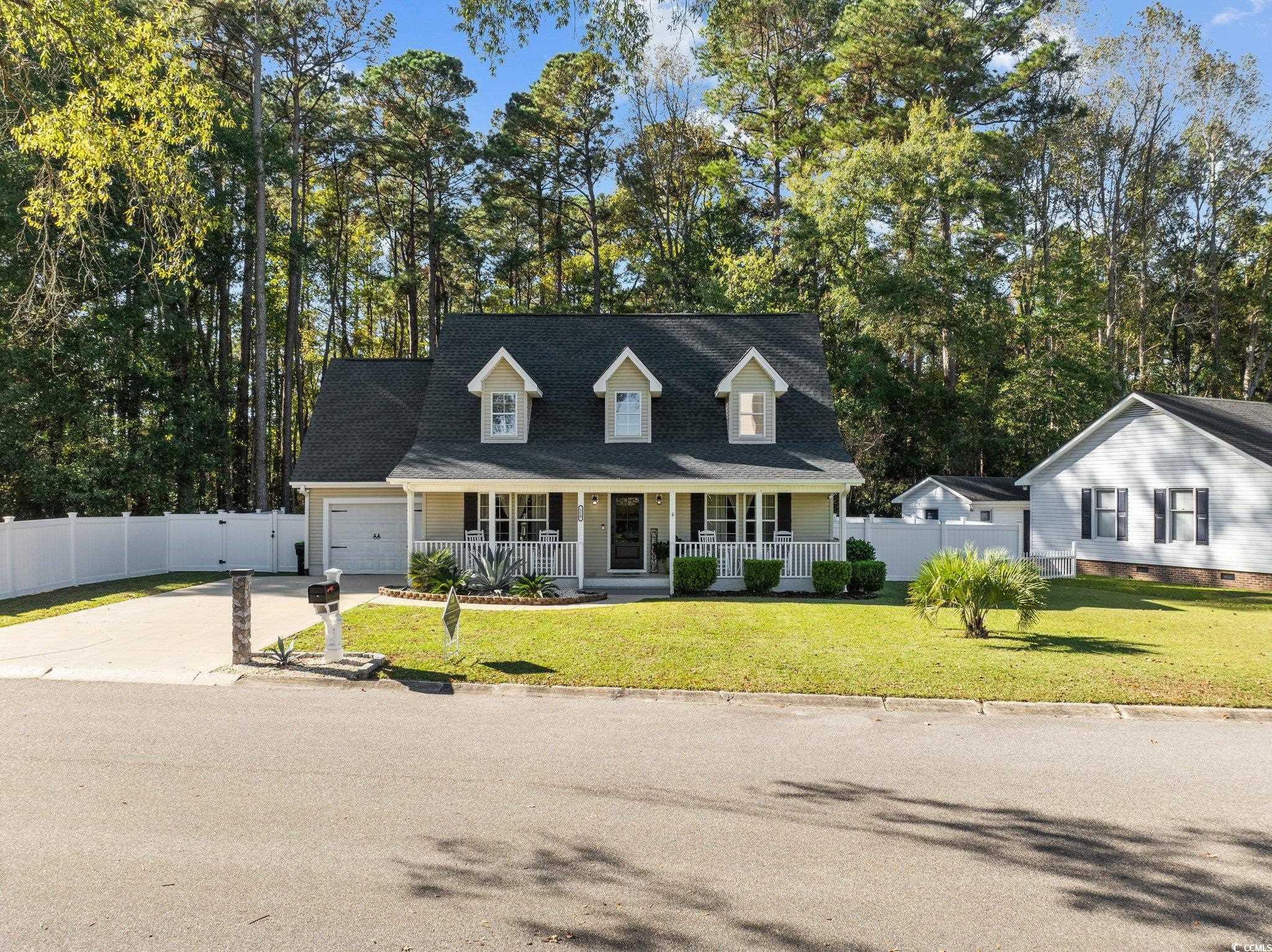 Cape cod house featuring a porch, a garage, and a