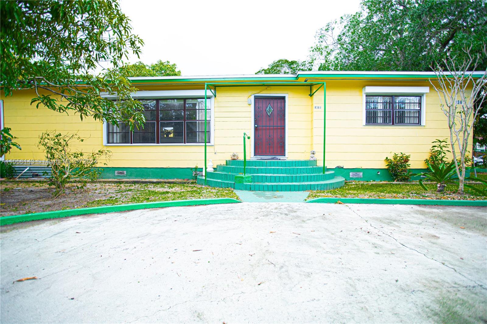 a view of a house with a backyard and a tree