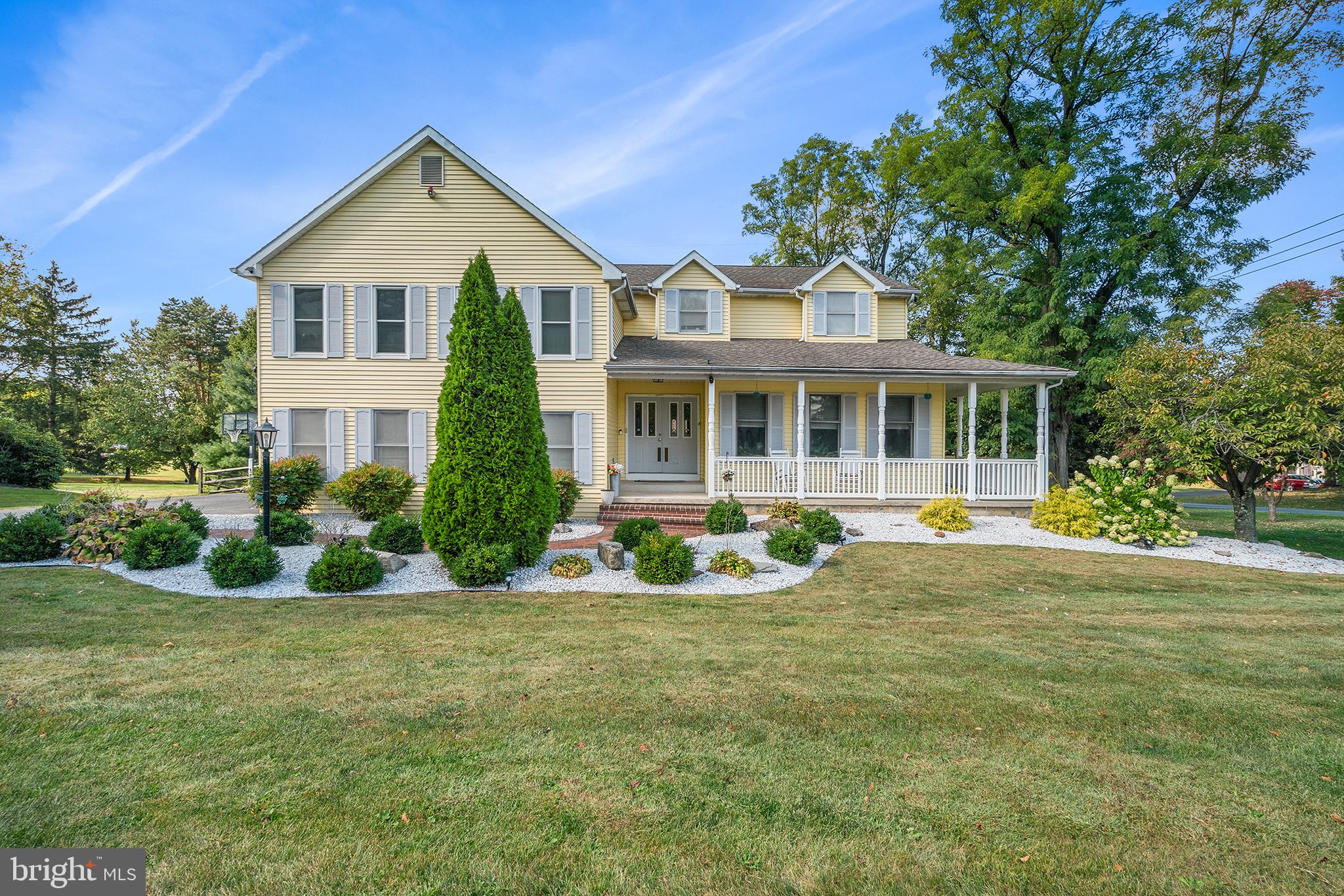 a front view of a house with yard and green space