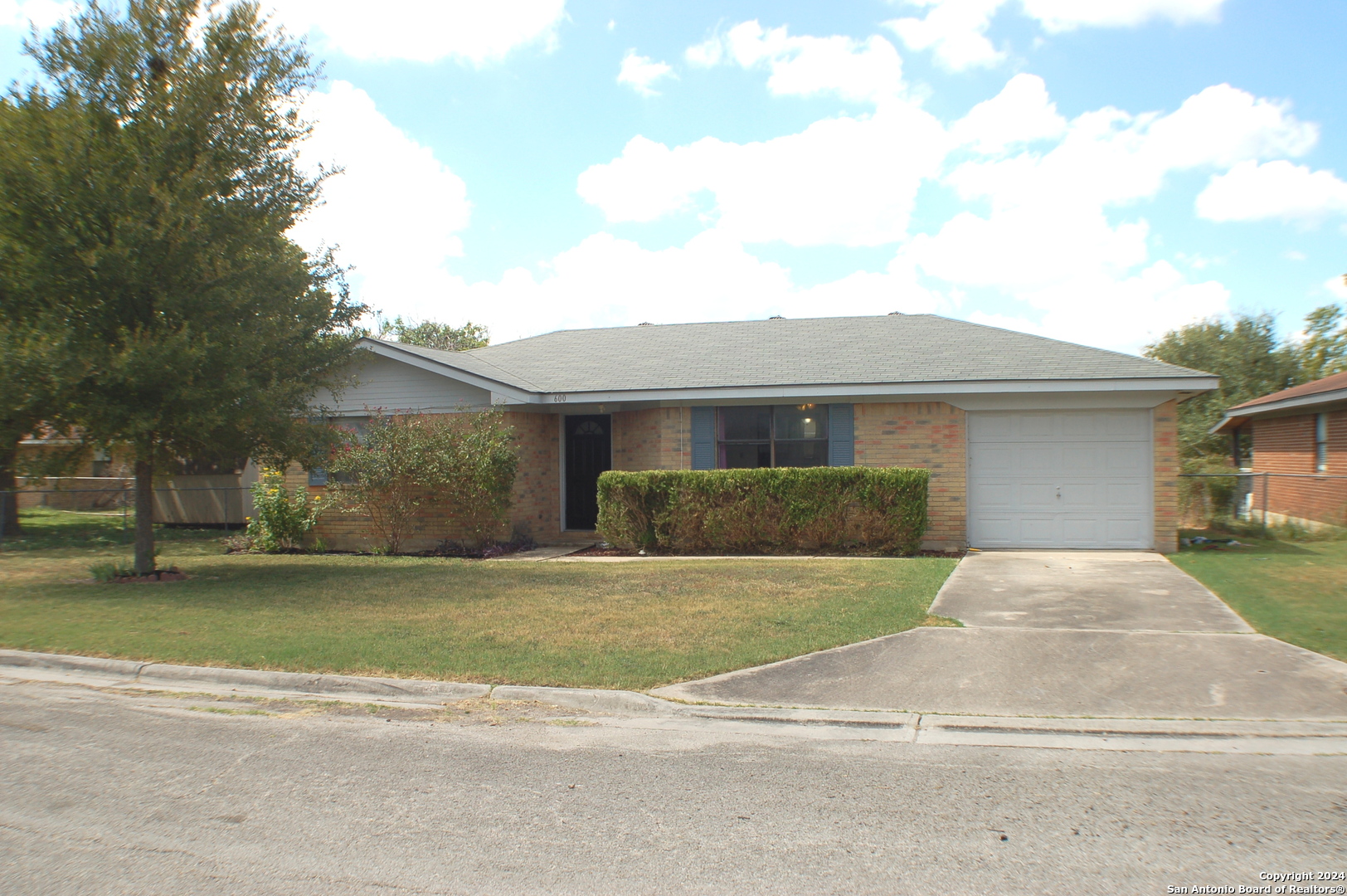 a front view of a house with a garden and yard