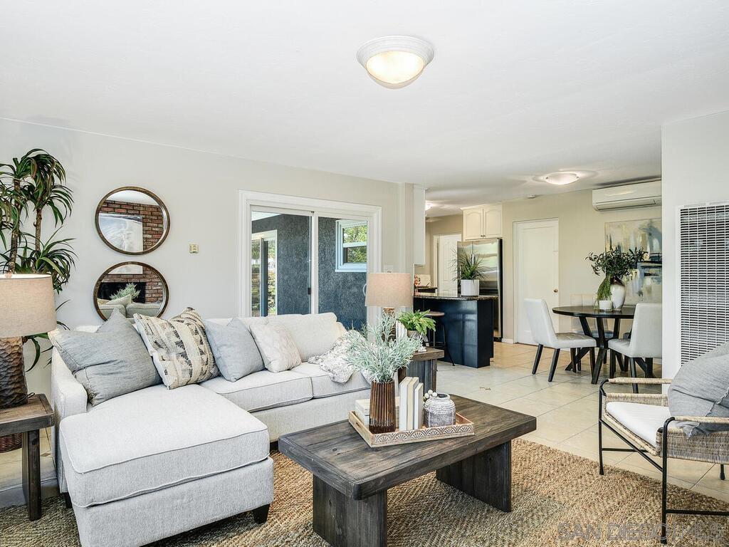 a living room with furniture a table and kitchen view