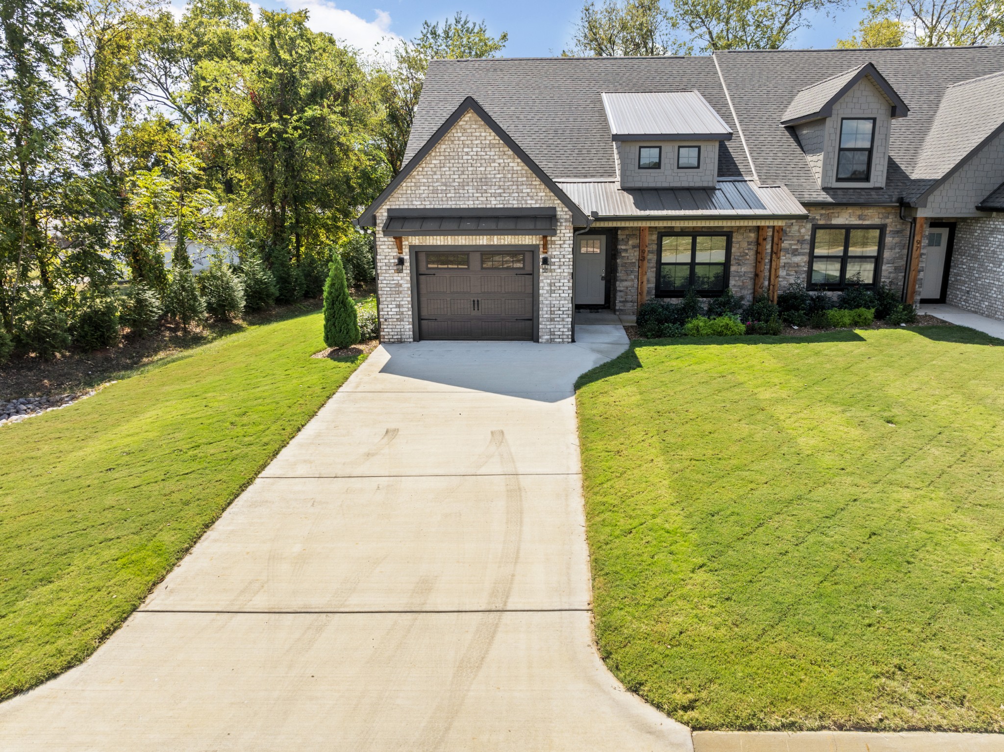 a front view of a house with a garden and yard