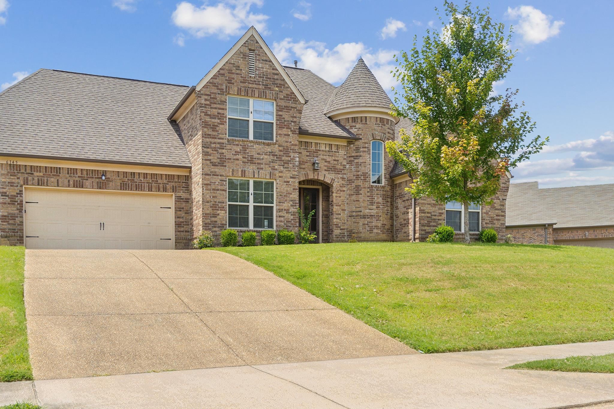 View of front of home with a garage and a front lawn