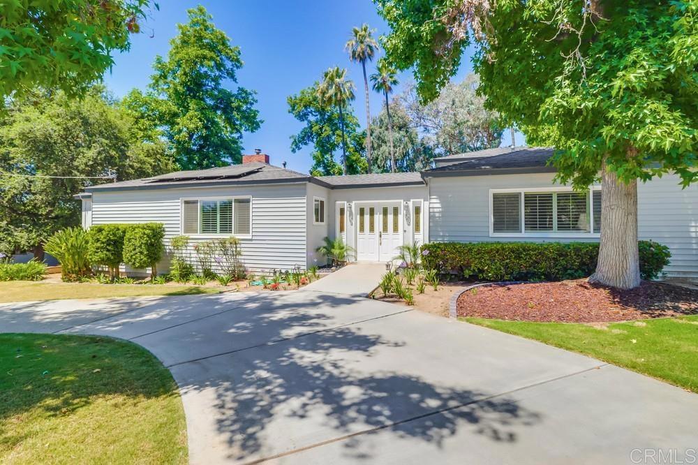 a view of a house with backyard and a tree