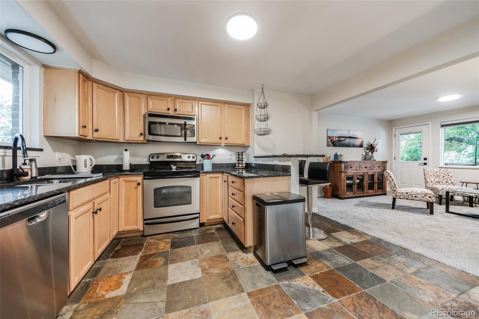 a kitchen with stainless steel appliances granite countertop a stove a sink and a microwave