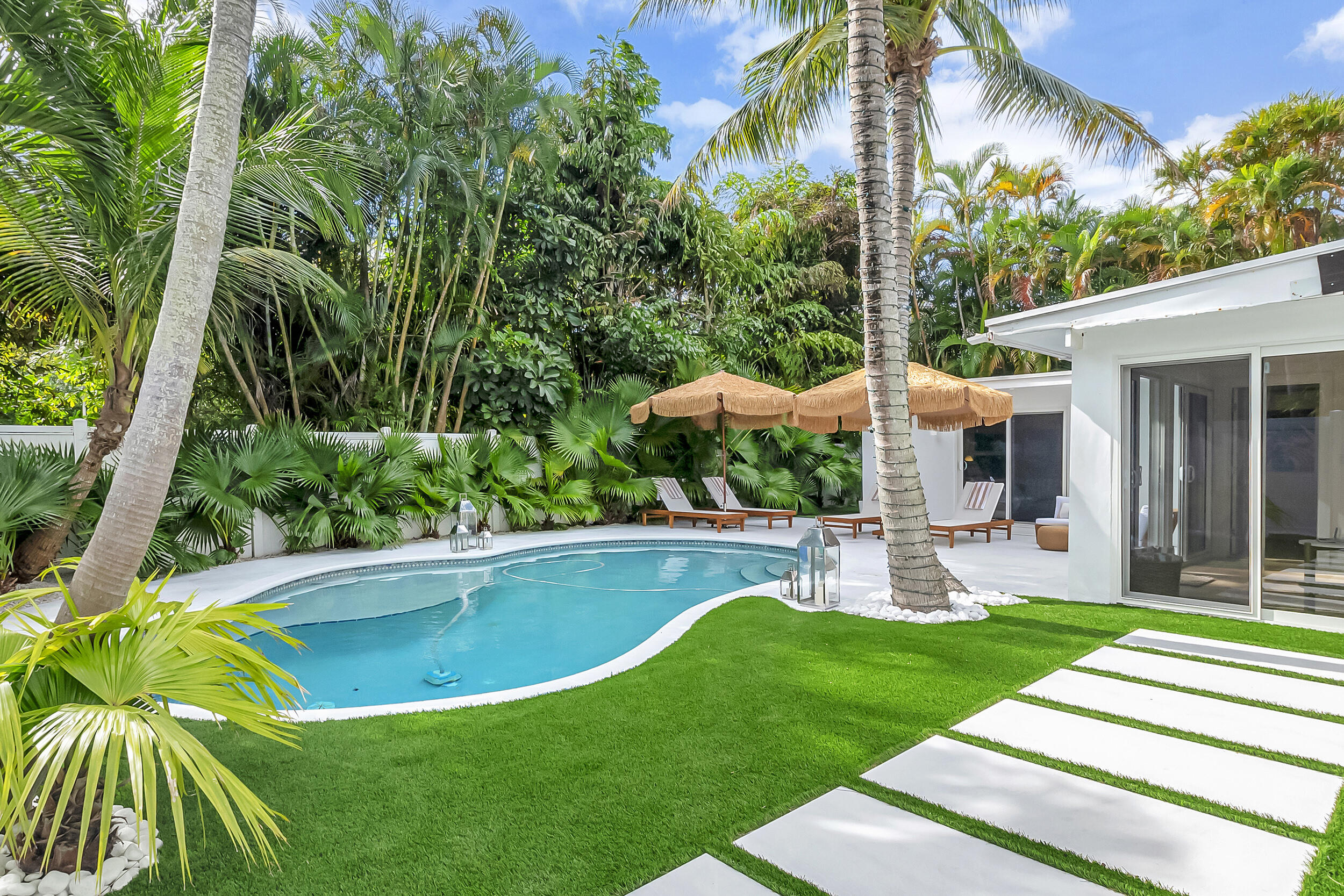 a view of a patio with table and chairs potted plants and palm tree