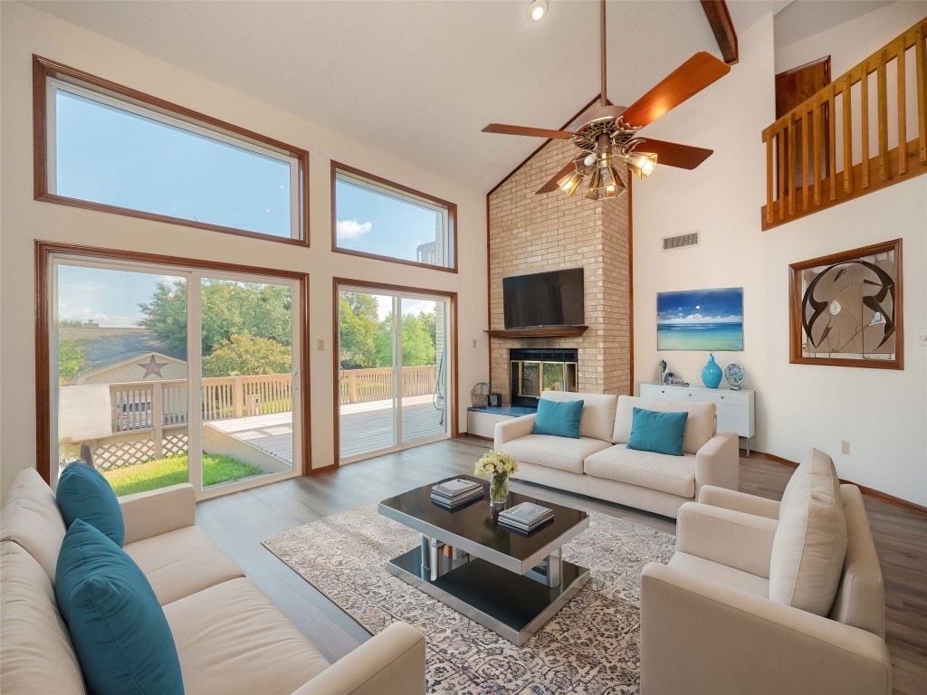 a living room with furniture a fireplace and a large window