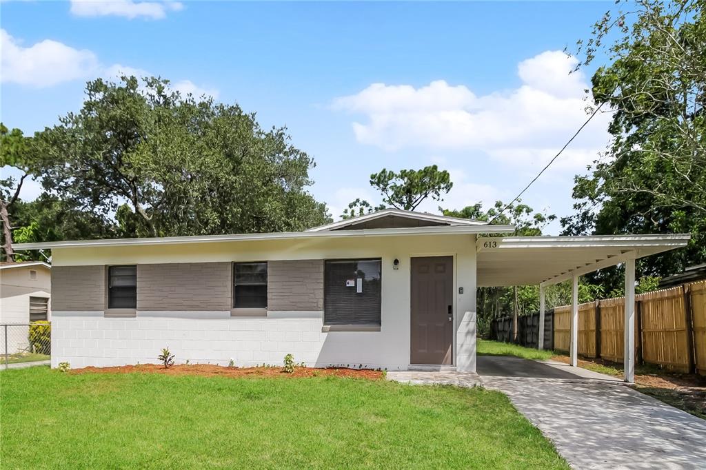 a view of a house with backyard and a tree