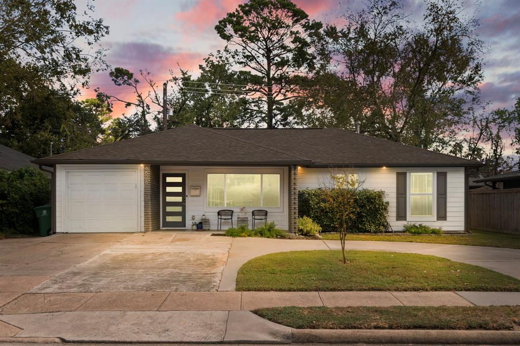 a front view of a house with a yard garage and outdoor seating