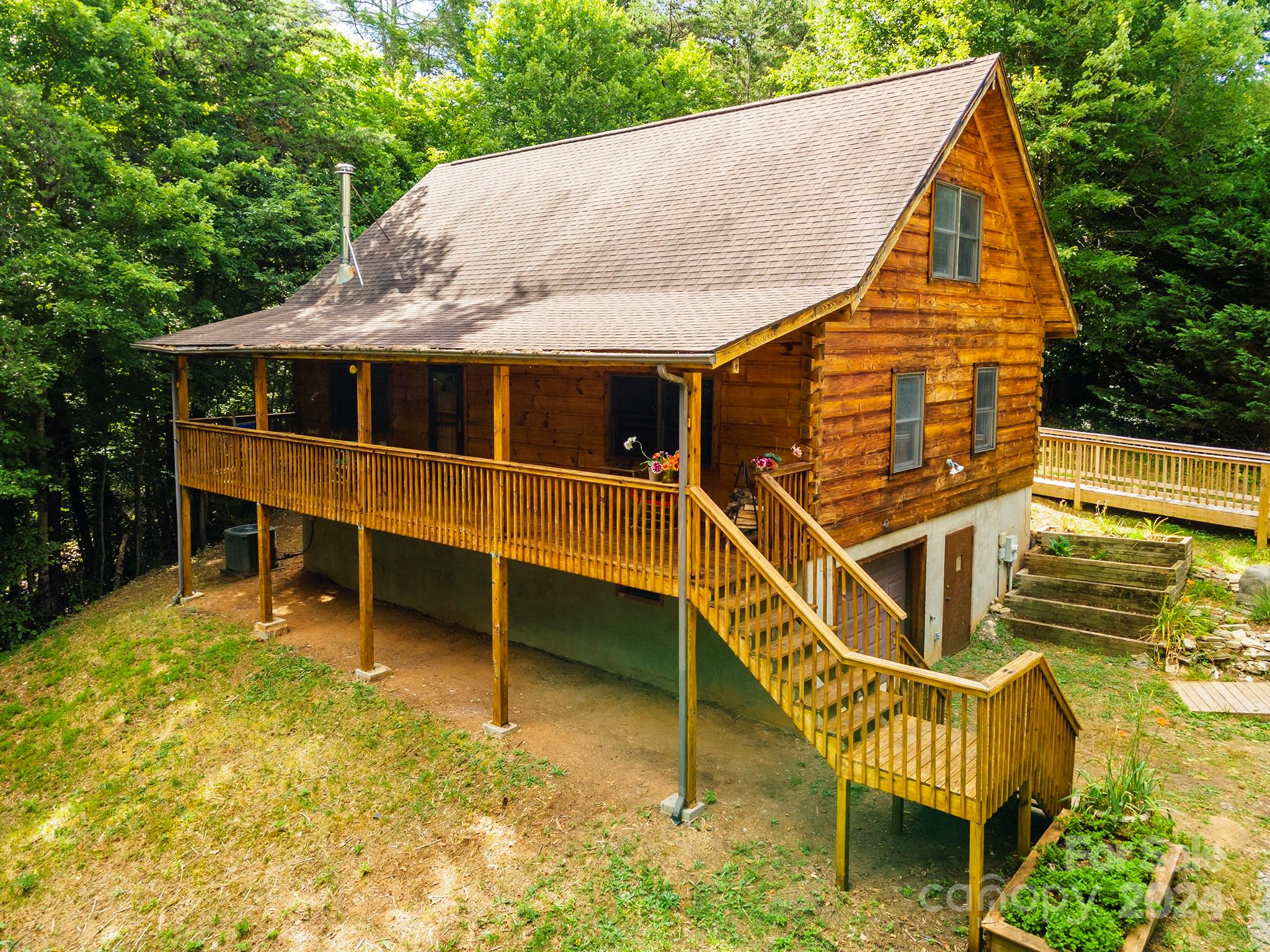 a view of a house with a wooden deck and a wooden bench