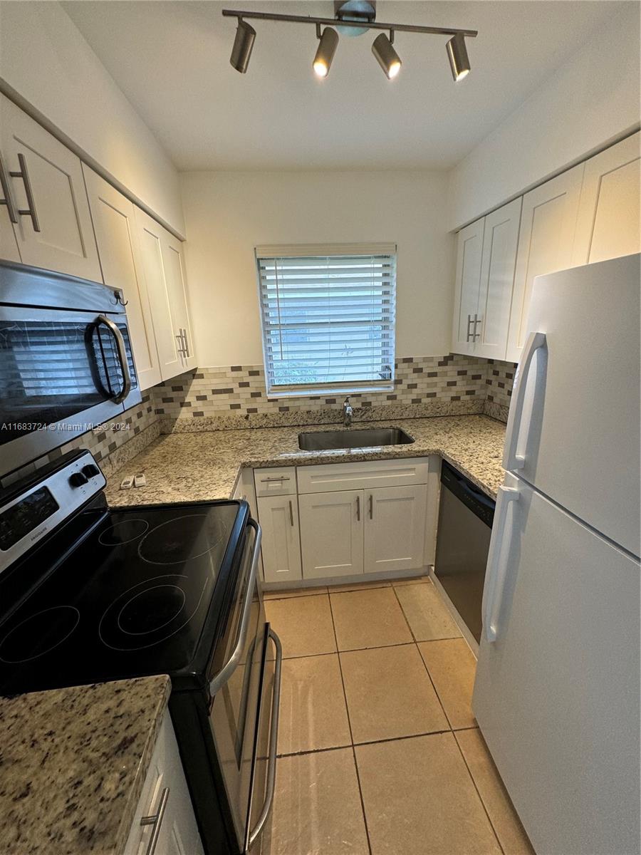 a kitchen with a stove a sink and a refrigerator