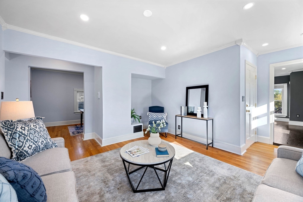 a living room with furniture and a wooden floor