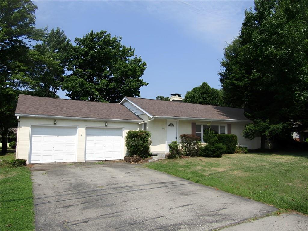 a front view of a house with a yard and a garage